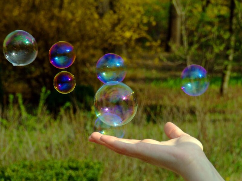 Hand holding floating bubbles
