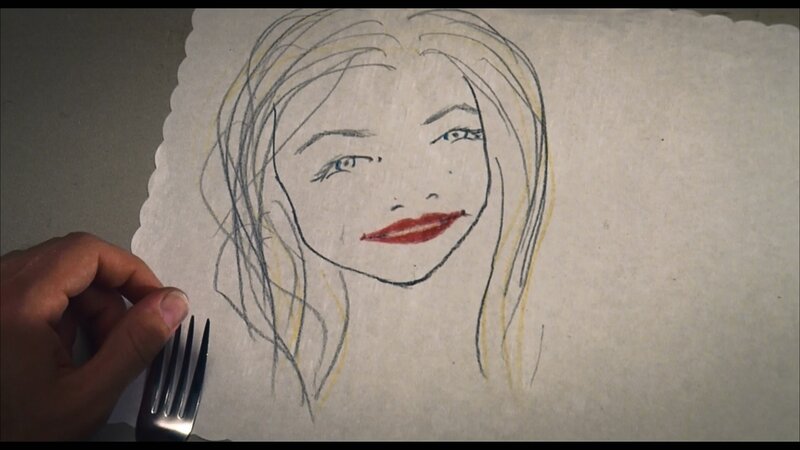 hand holding fork near drawing