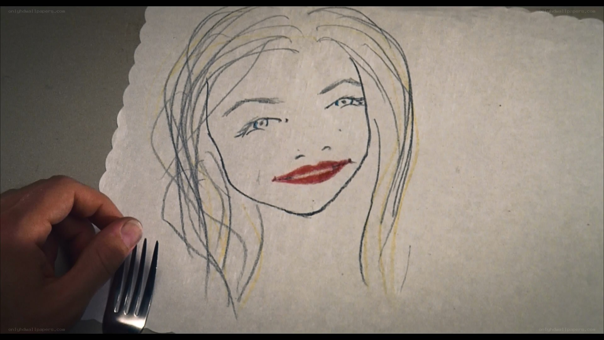 hand holding fork near drawing