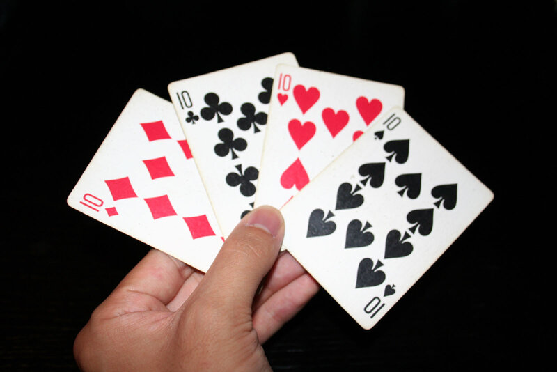 Hand Holding Four Cards