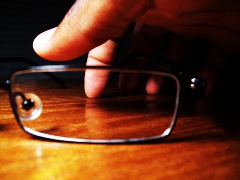 Hand holding glasses on wood