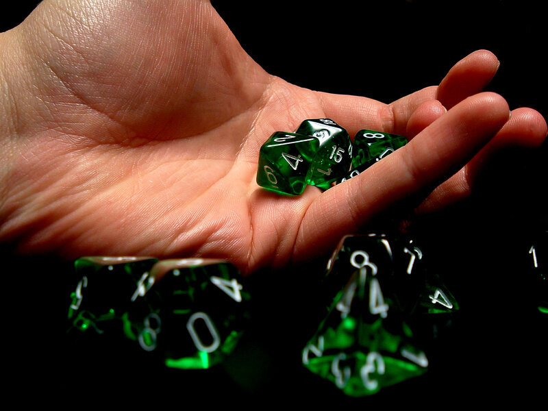 Hand holding green dice