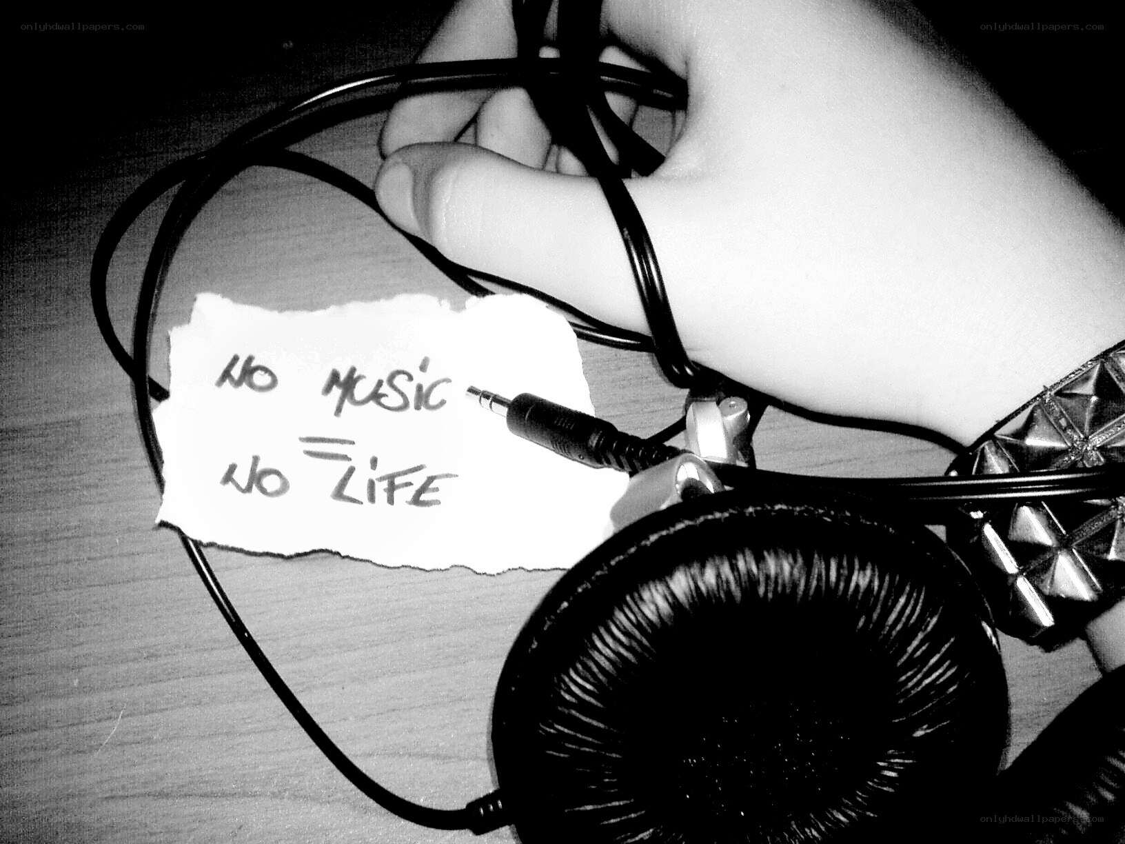 Hand holding headphones with note