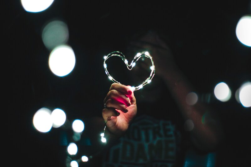 hand holding heart-shaped lights
