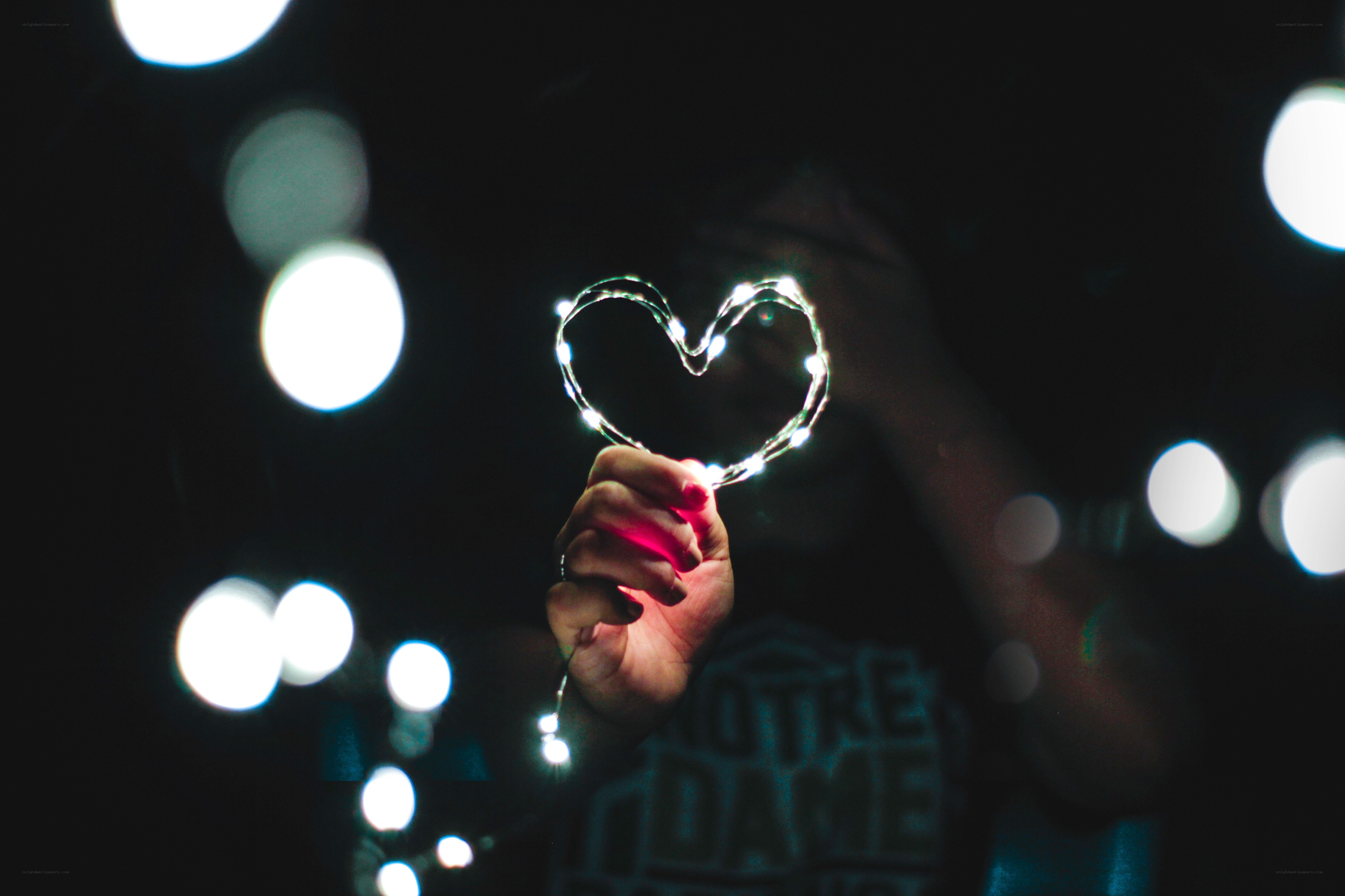 hand holding heart-shaped lights