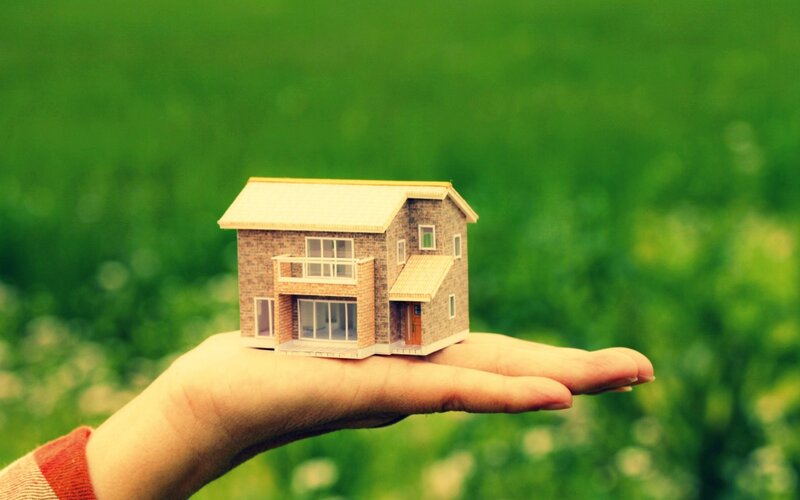 Hand Holding House Model — Green