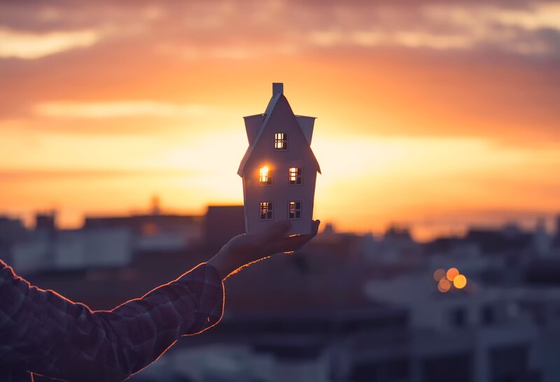 Hand Holding House Model — Orange