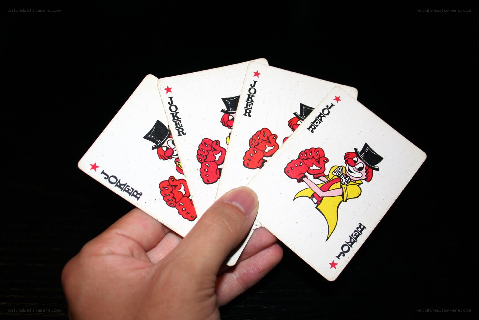 hand holding joker cards