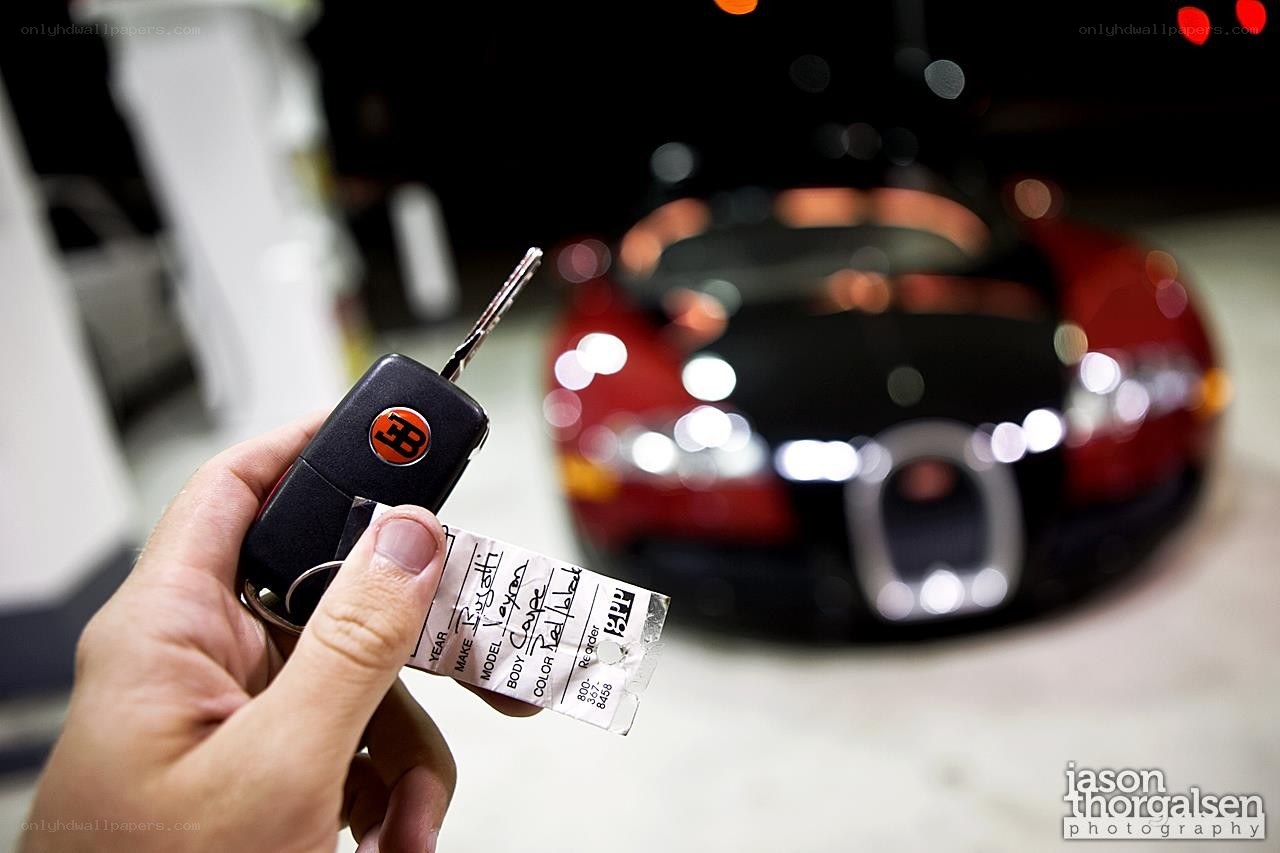 hand holding key with car in background