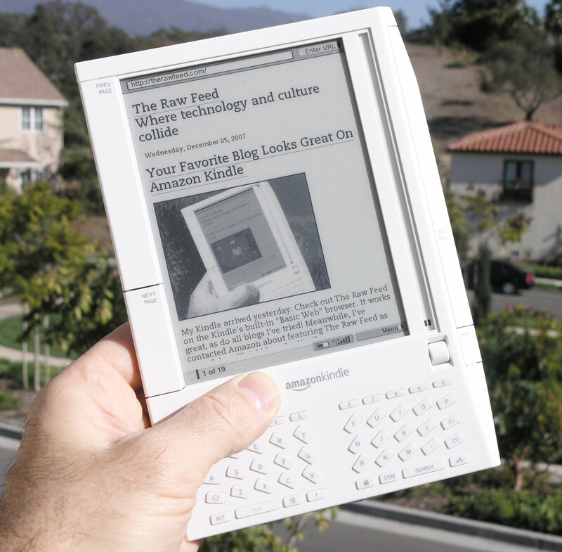 Hand holding Kindle reading blog