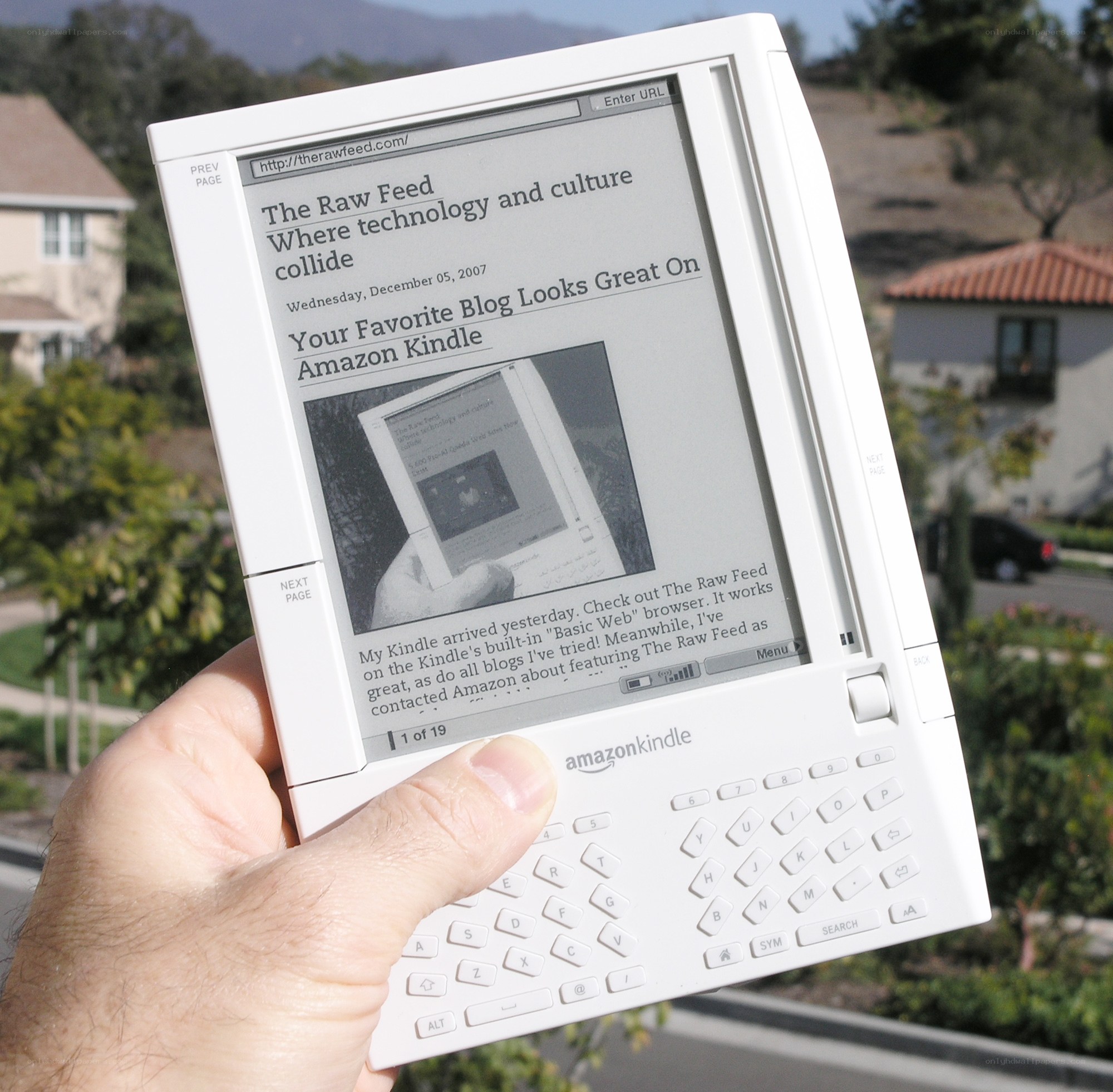 Hand holding Kindle reading blog