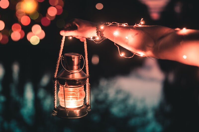 Hand holding lantern at night