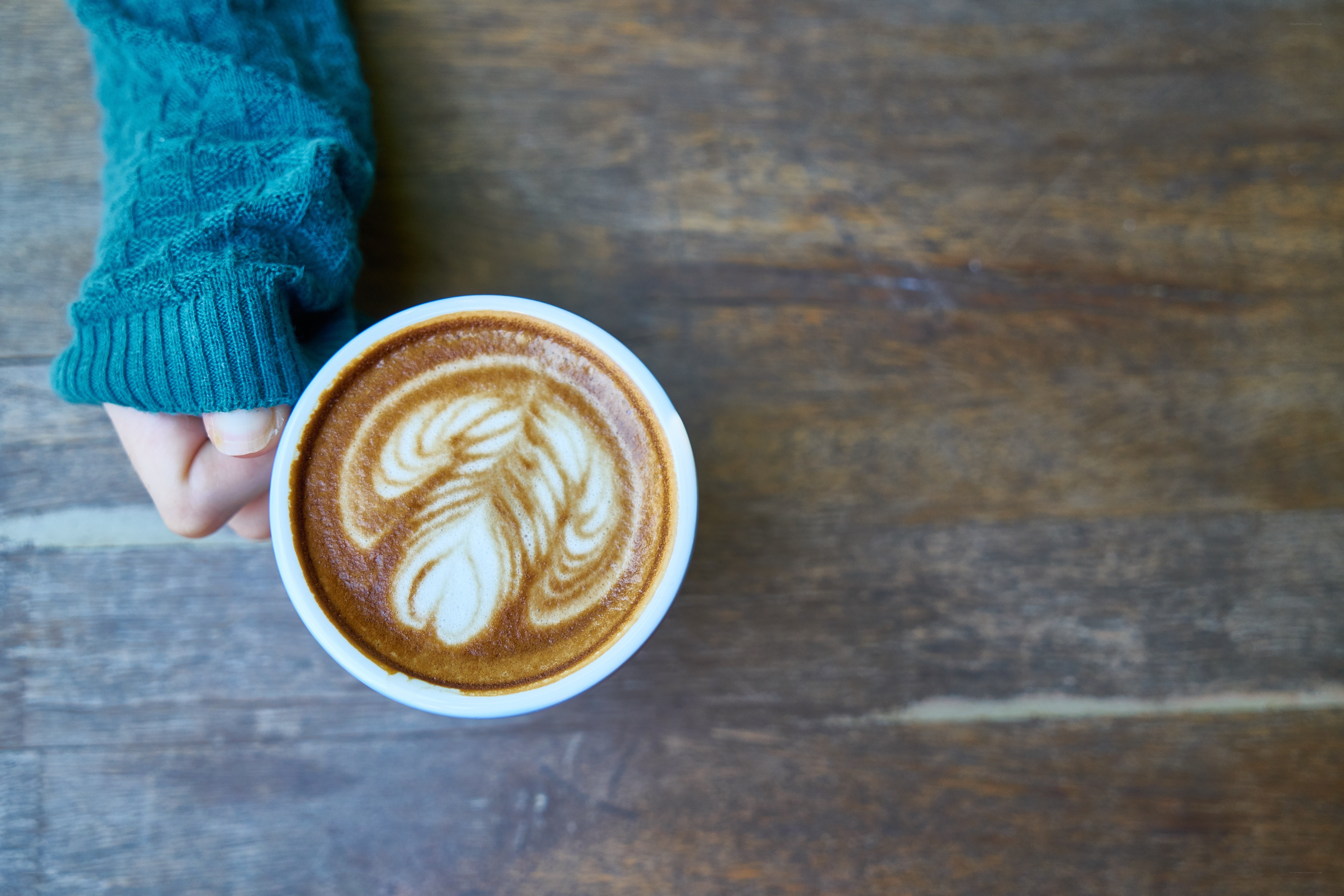 hand holding latte art coffee