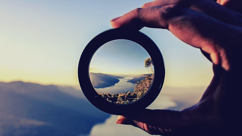 Hand Holding Lens — Blue, Serene