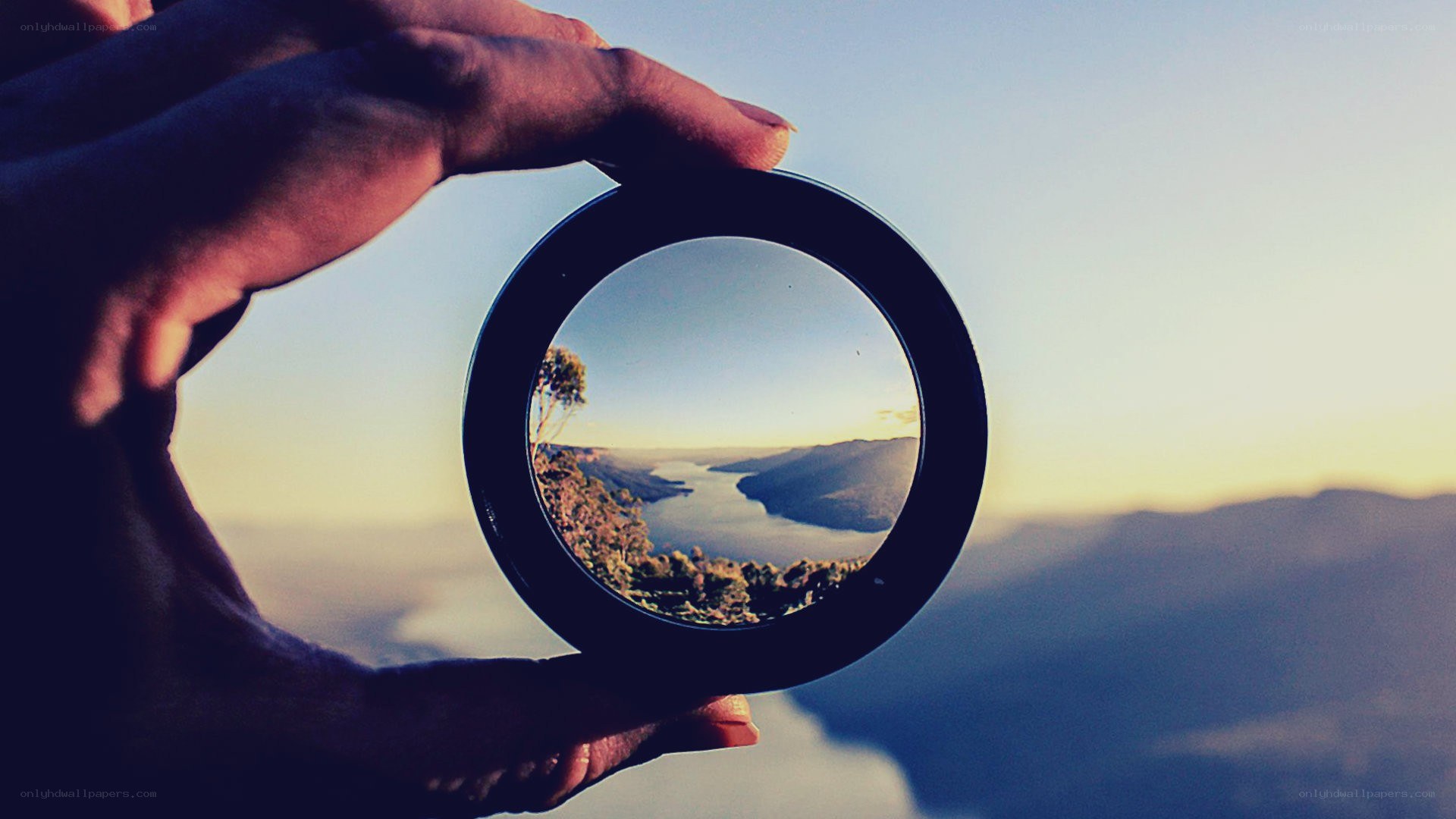 hand holding lens over landscape