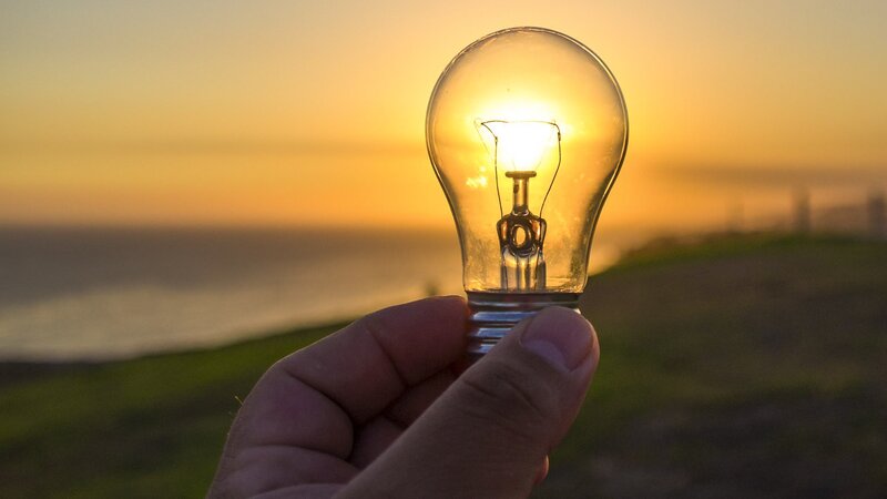 Hand Holding Light Bulb — Yellow