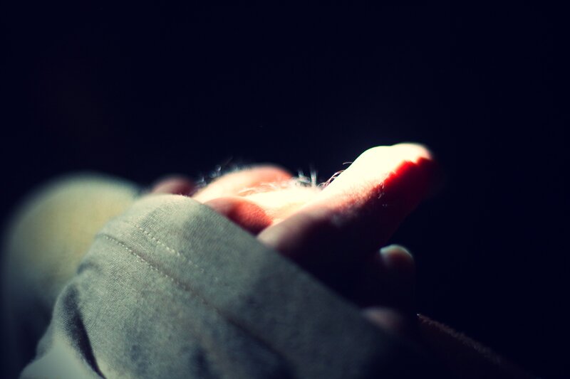 hand holding light in darkness