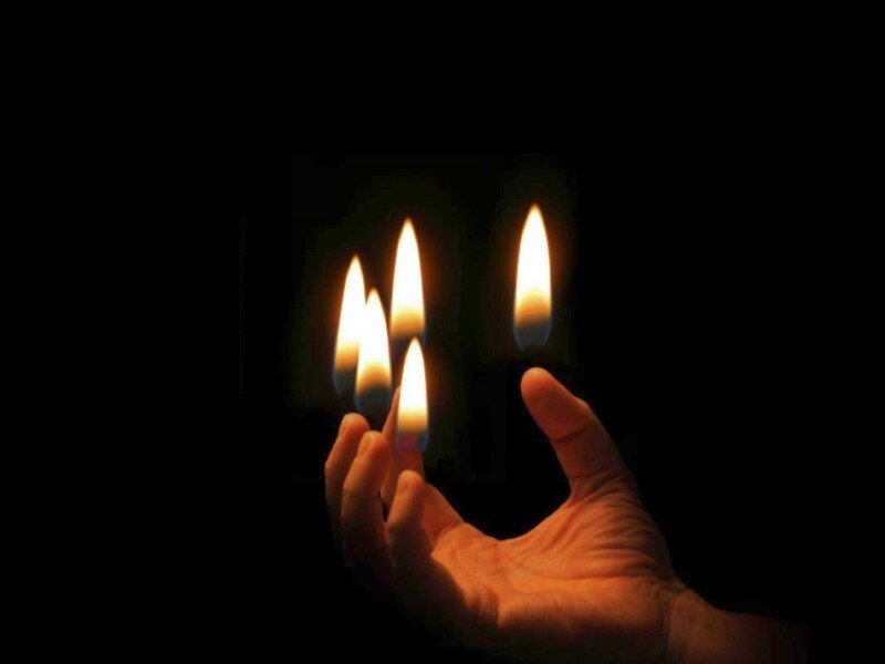 hand holding lit candles