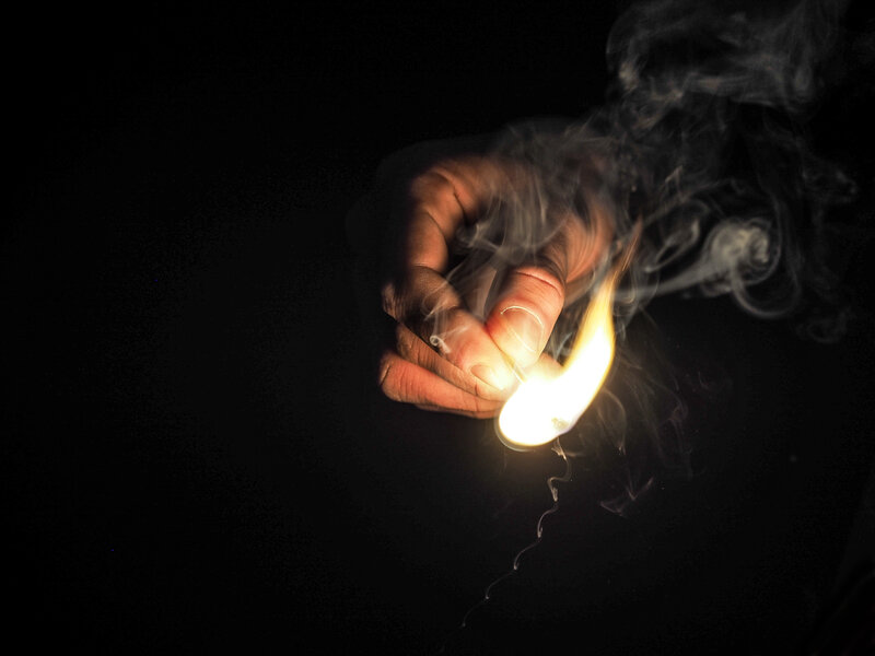 Hand Holding Lit Match