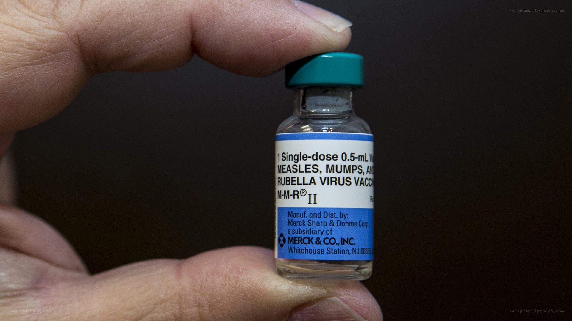 Hand holding MMR vaccine vial