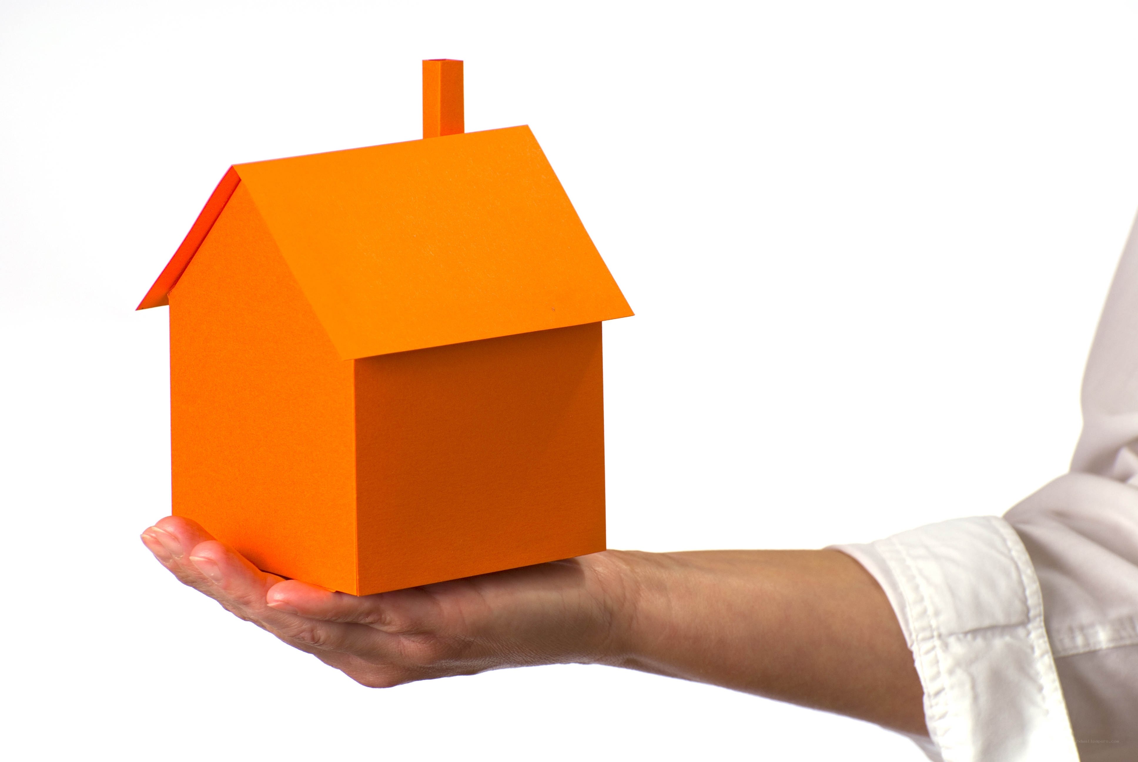 hand holding orange house model