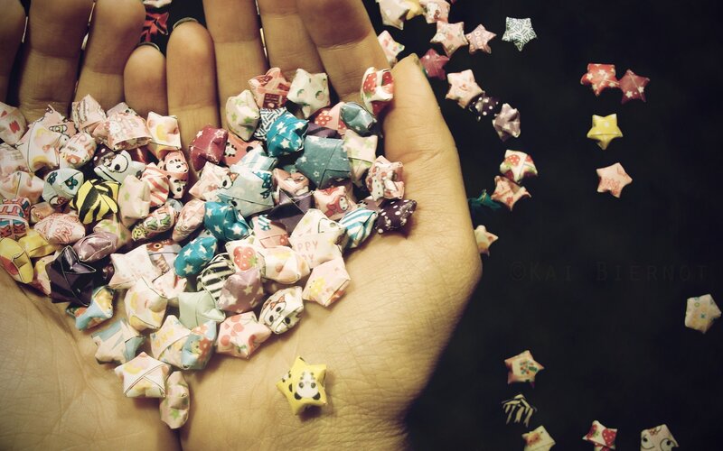 hand holding origami stars