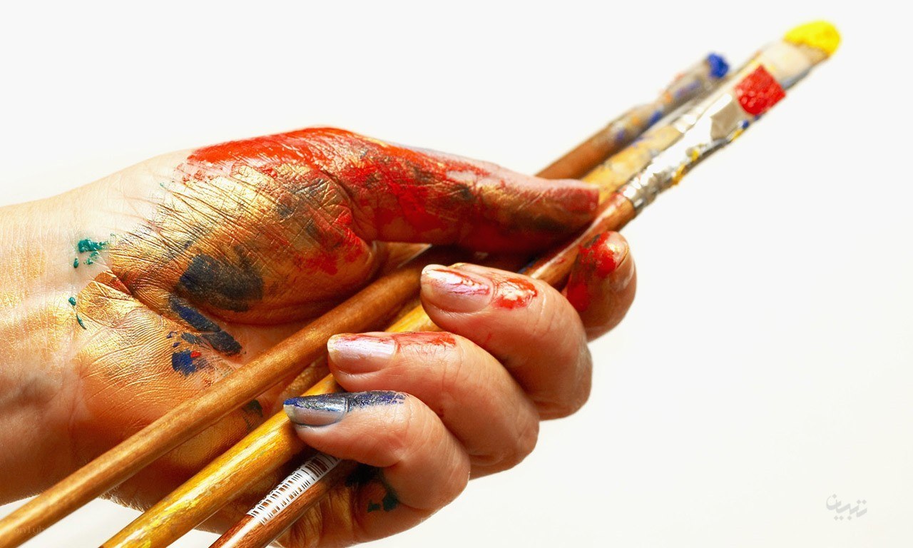 hand holding paintbrushes