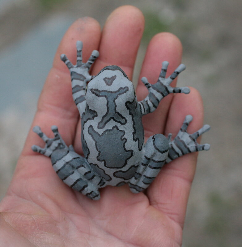 hand holding painted frog figurine