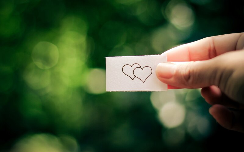Hand Holding Paper with Hearts