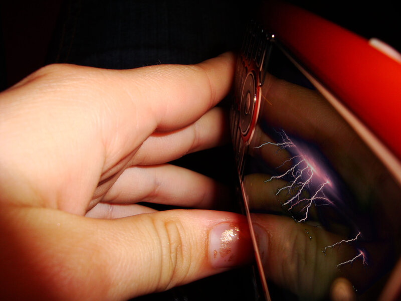hand holding phone with lightning reflection