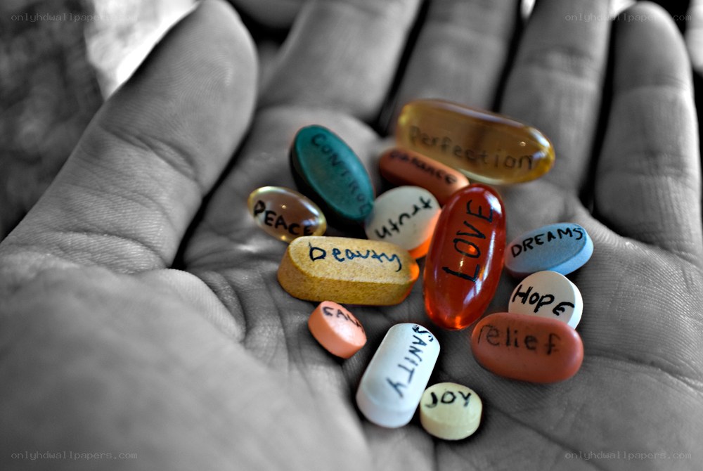 hand holding pills with words
