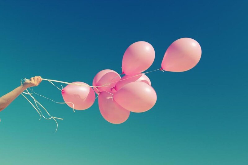 Hand Holding Pink Balloons — Serene