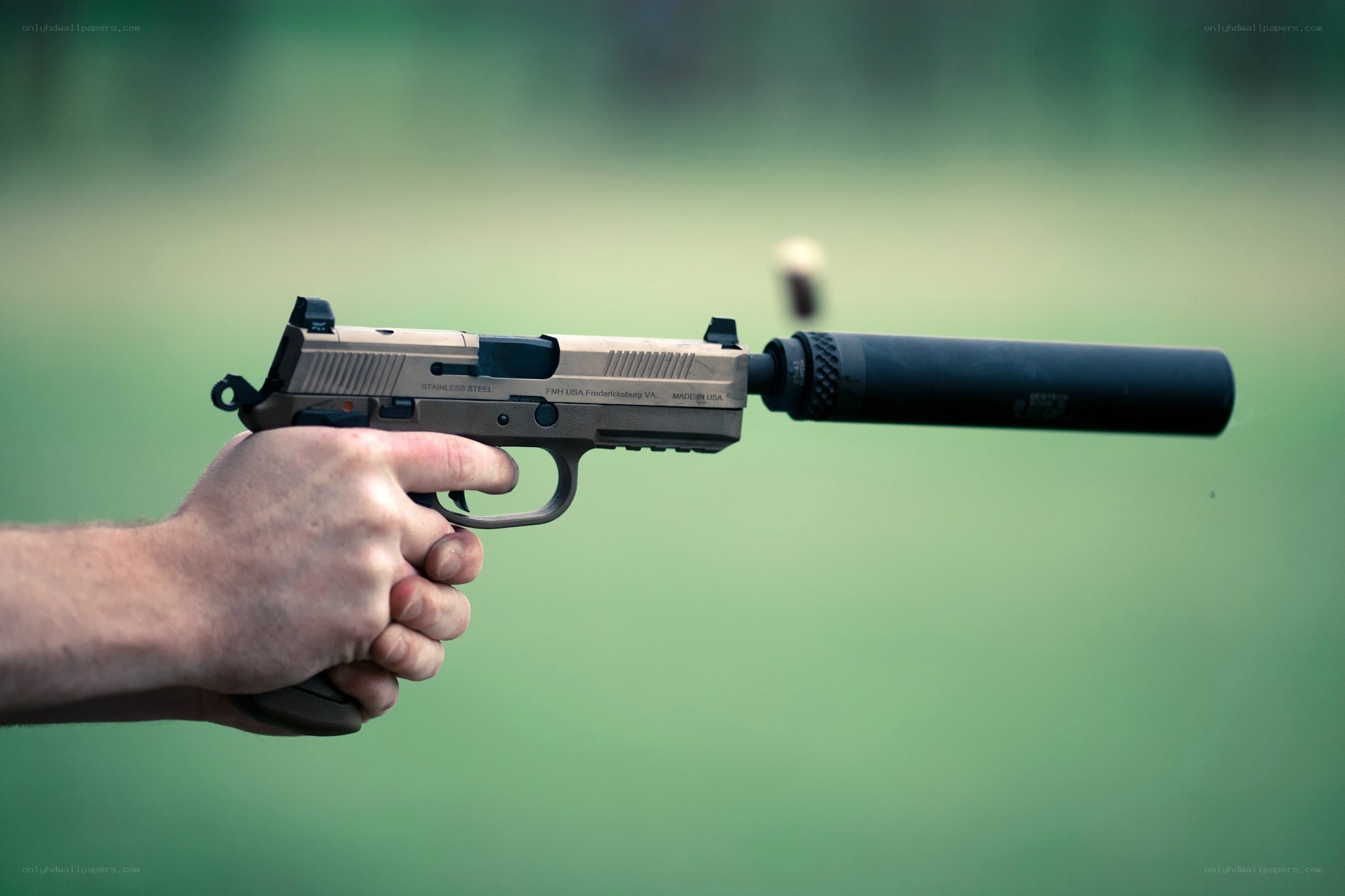 hand holding pistol with suppressor