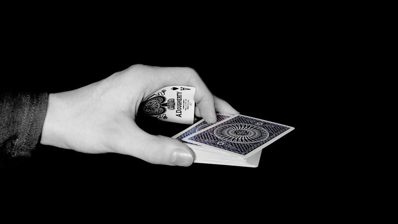 Hand Holding Playing Cards — Black, Dramatic, Photograph