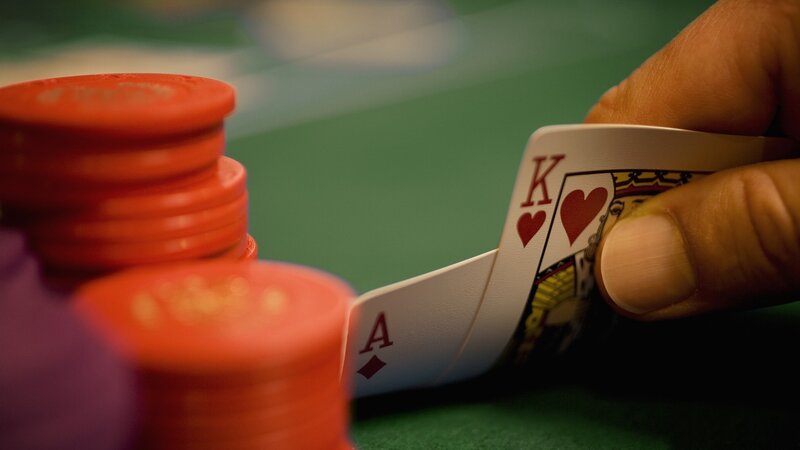 Hand Holding Poker Cards — Red, Tense