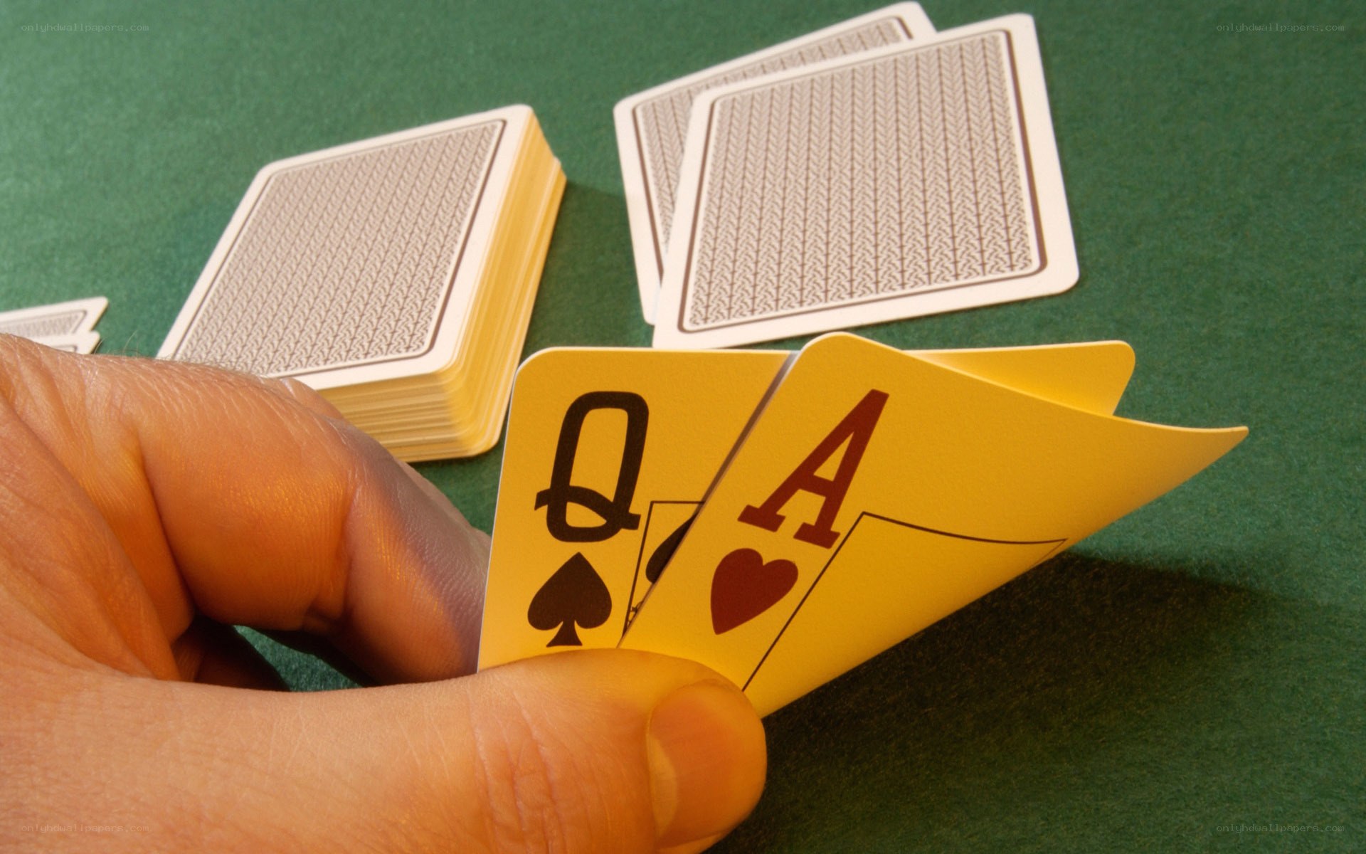 hand holding queen and ace cards