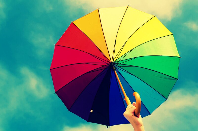 Hand Holding Rainbow Umbrella — Blue