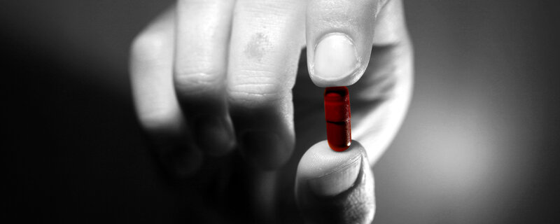 hand holding red pill