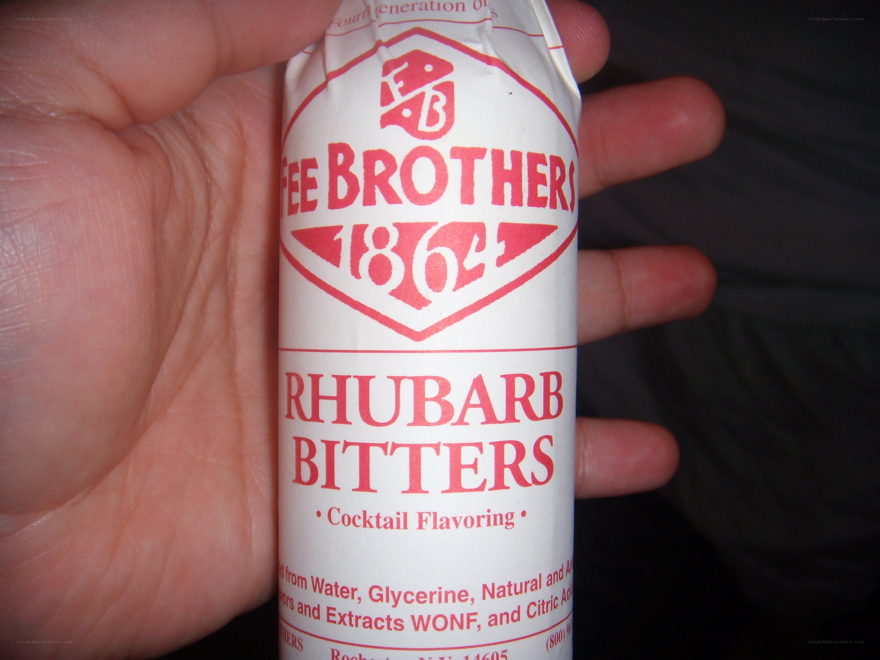 hand holding rhubarb bitters bottle