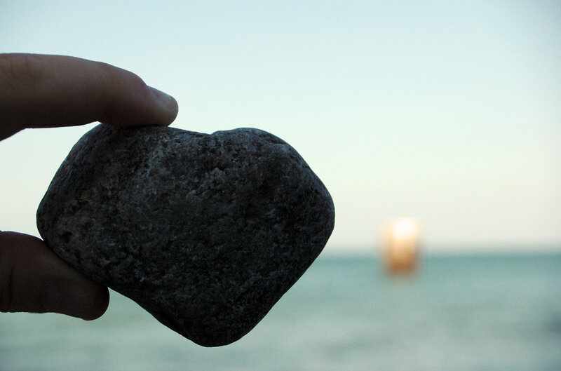 hand holding rock at beach