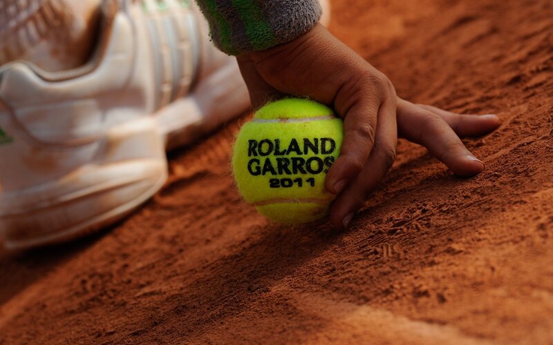 Hand holding Roland Garros tennis ball