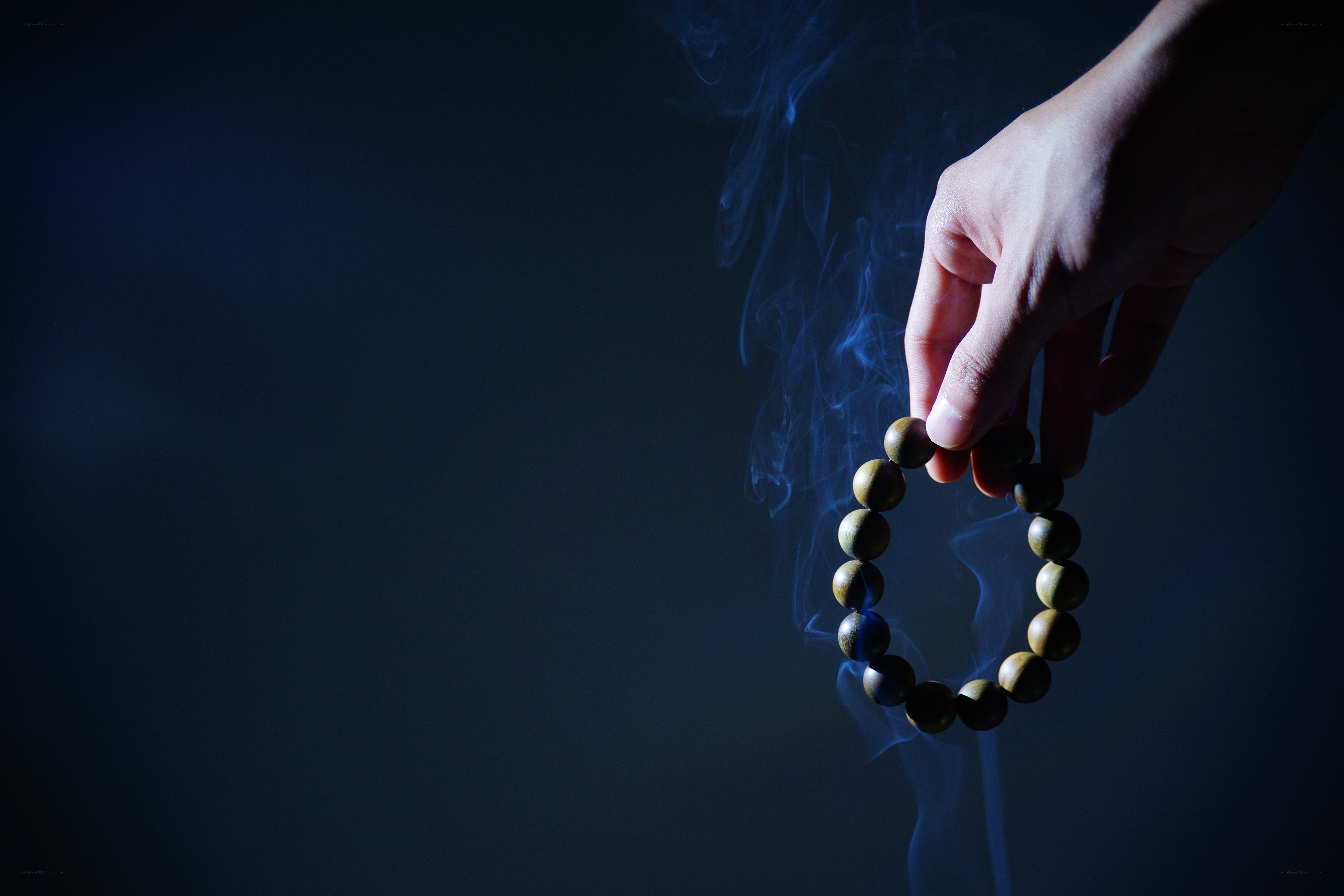Hand holding smoky prayer beads