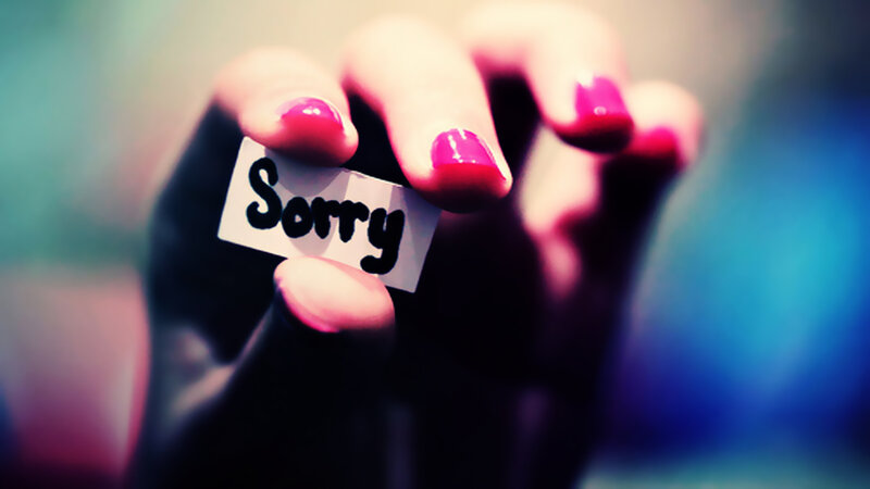 Hand Holding Sorry Note