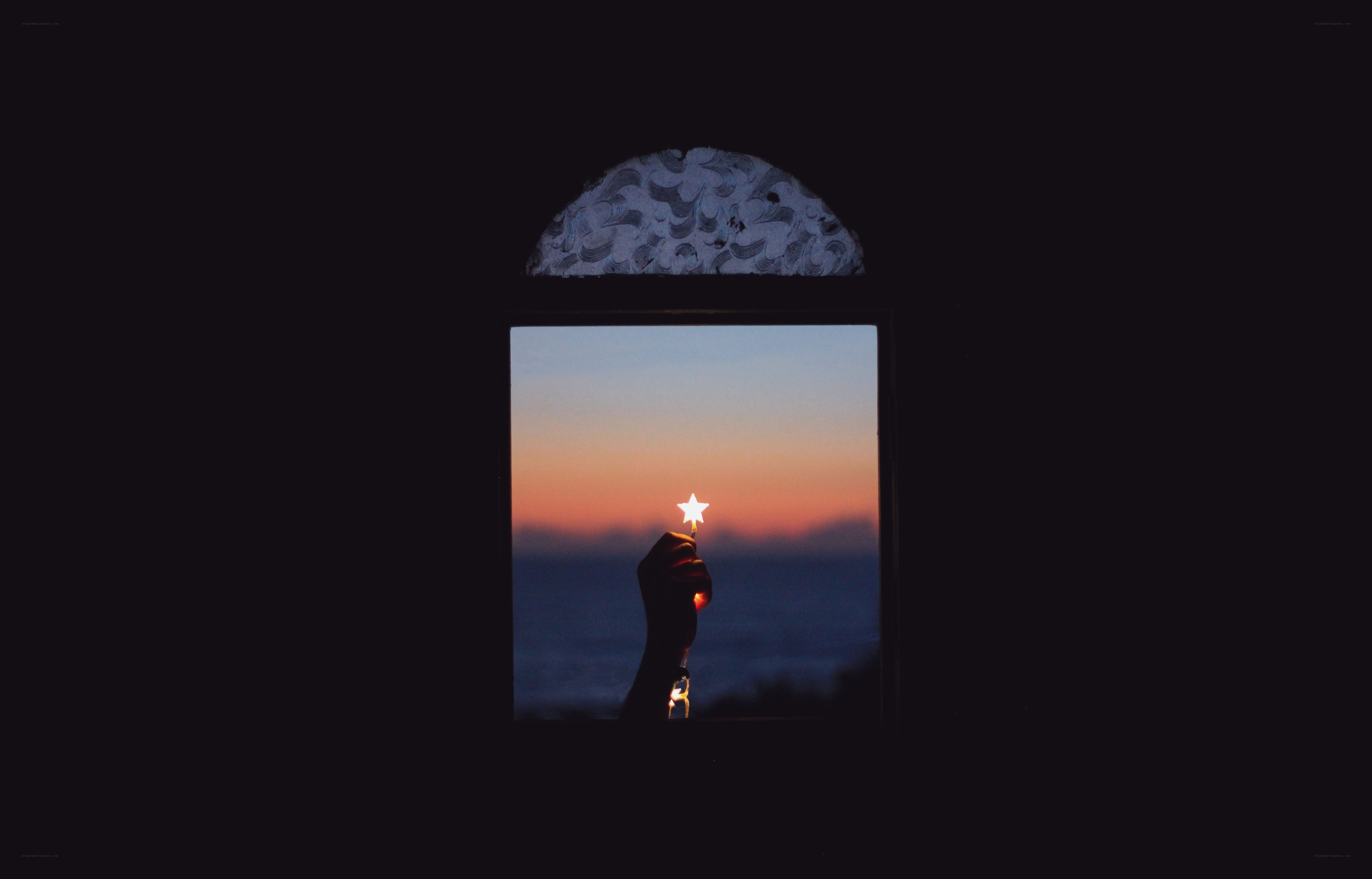 Hand holding star light at sunset