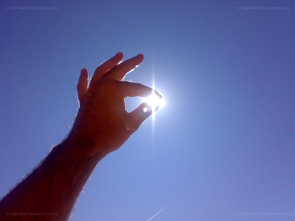hand holding sun in sky