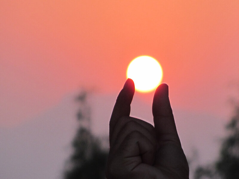 Hand Holding Sun — Orange