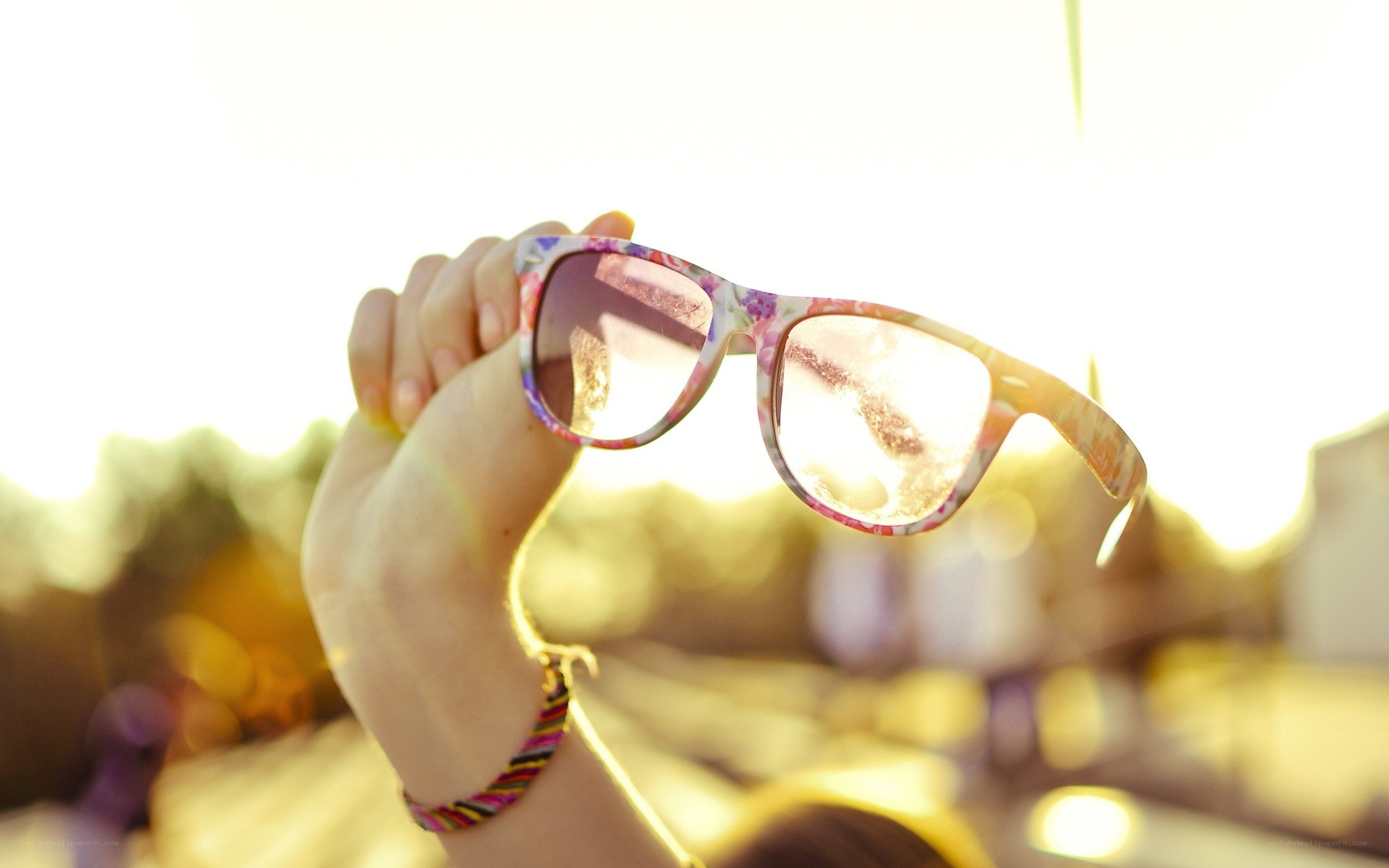 hand holding sunglasses in sunlight
