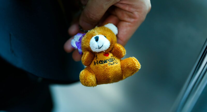 Hand holding teddy bear keychain