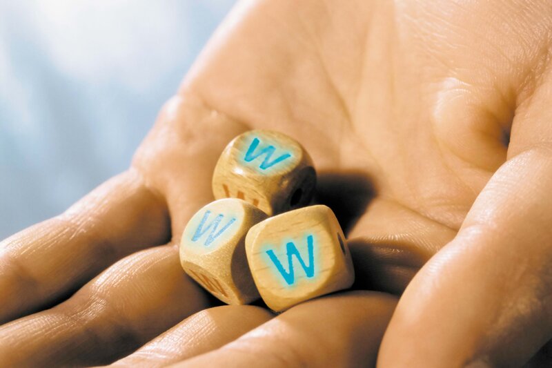 Hand holding wooden cubes with letter W