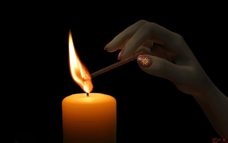 hand lighting a candle